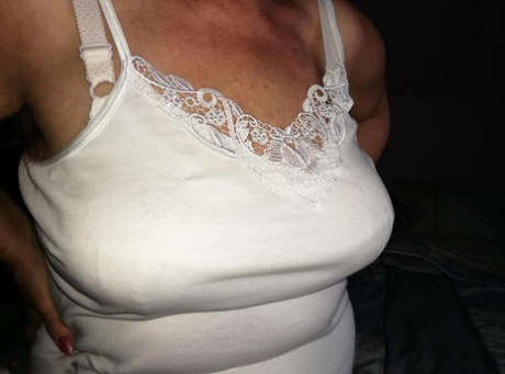 Naughty granny exposes her boobs while changing attire in nylons and heels