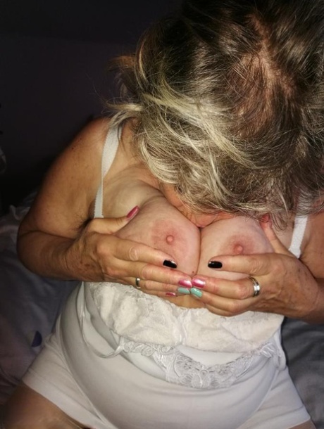 Naughty granny exposes her boobs while changing attire in nylons and heels