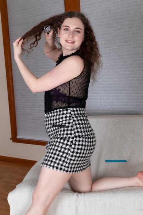 Curly-haired American Caralynn Rose undresses & rubs her furry vagina